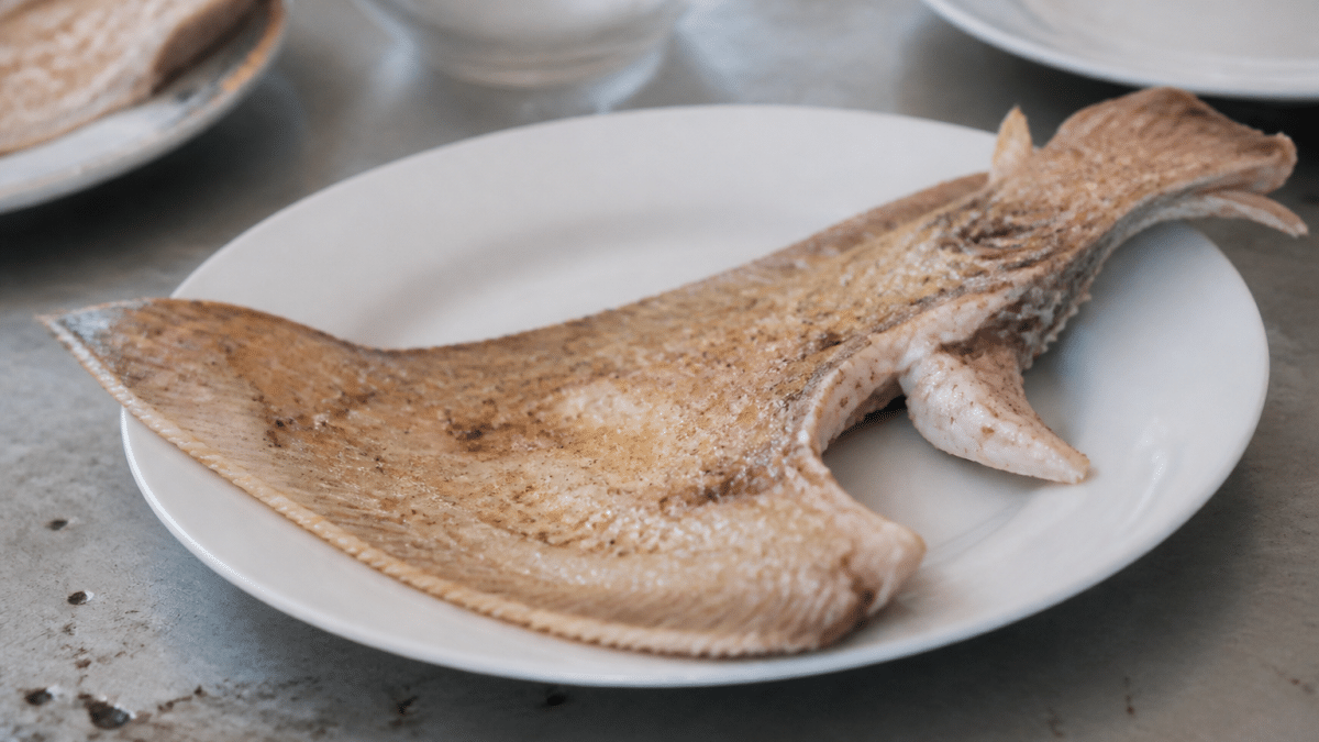 Aile de raie cuite posee dans assiette blanche