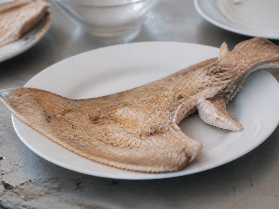 Aile de raie cuite posee dans assiette blanche