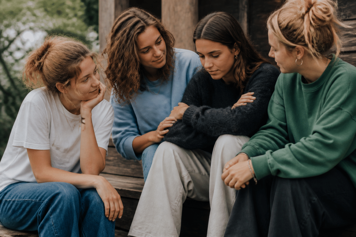 Groupe d'amis assis ensemble, conversation bienveillante et soutien mutuel