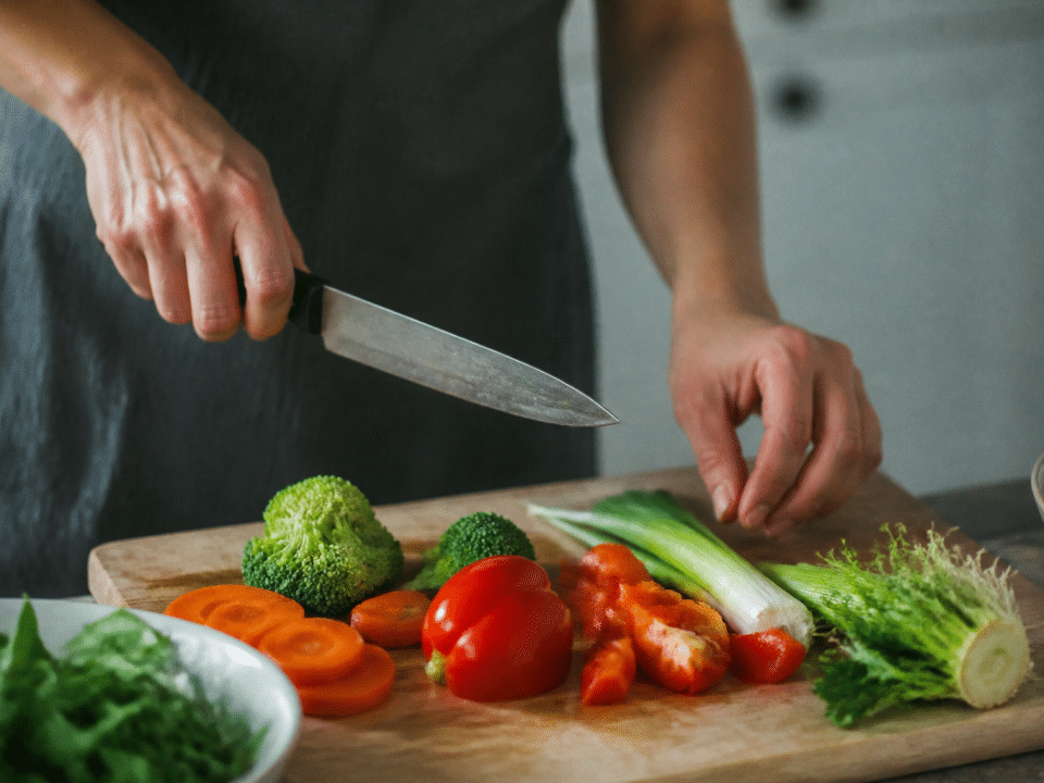 Mains tenant couteau au-dessus planche decoupage avec legumes