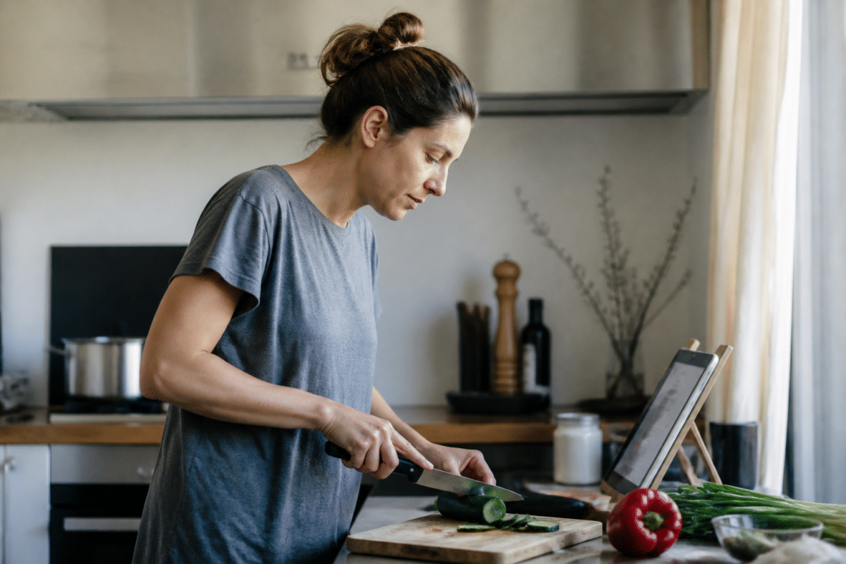 Personne suivant recette sur tablette en cuisinant dans cuisine moderne