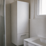 Armoire blanche compacte adossee au mur salle bain