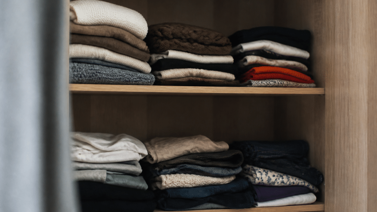 Vetements plies et empiles sur etageres ouvertes d'armoire