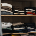Vetements plies et empiles sur etageres ouvertes d'armoire