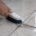 Brosse frottant vigoureusement joint carrelage tache noire épaisse