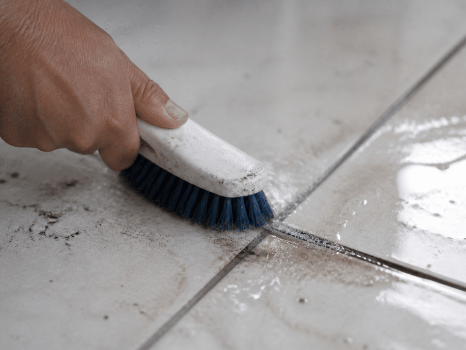 Brosse frottant vigoureusement joint carrelage tache noire épaisse
