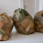 Trois sacs d'epicerie remplis sur table blanche