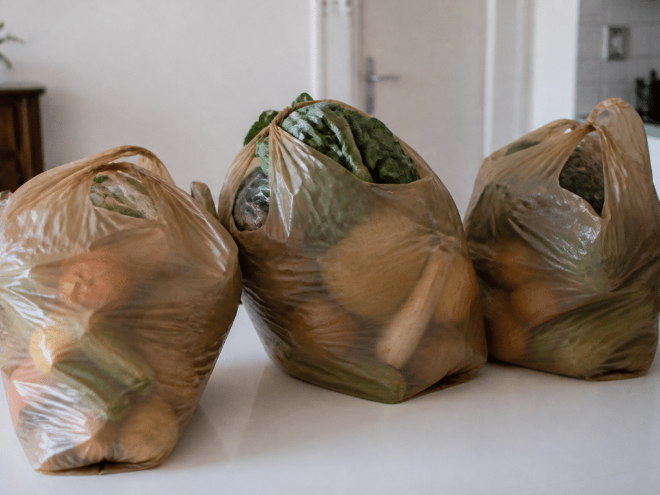 Trois sacs d'epicerie remplis sur table blanche