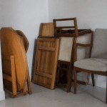 Pieces de mobilier empiles contre mur blanc domestique