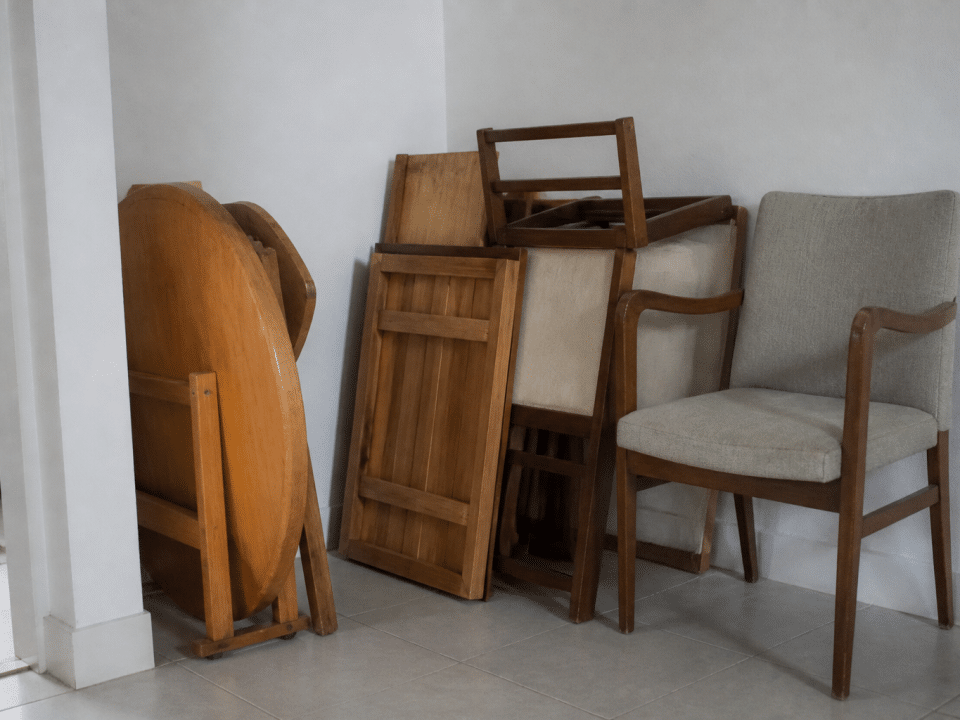 Pieces de mobilier empiles contre mur blanc domestique