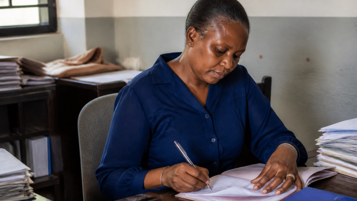 Personne assise a un bureau remplissant des documents officiels