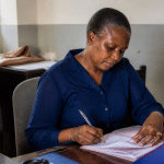 Personne assise a un bureau remplissant des documents officiels