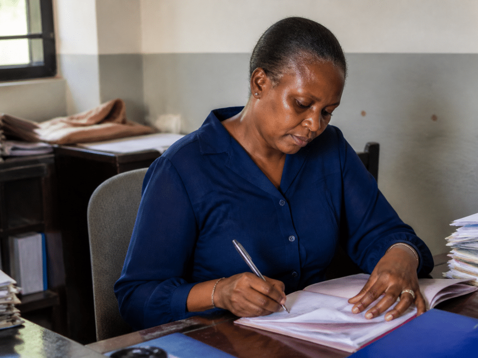 Personne assise a un bureau remplissant des documents officiels