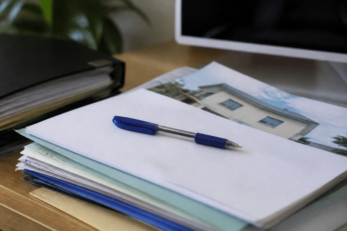 Dossier bancaire avec documents immobiliers et stylo bleu