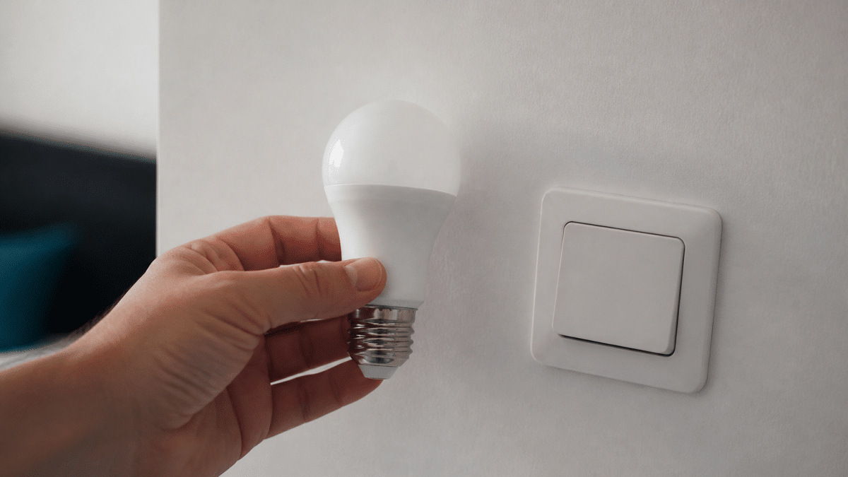 Main tenant ampoule LED pres d'interrupteur eteint
