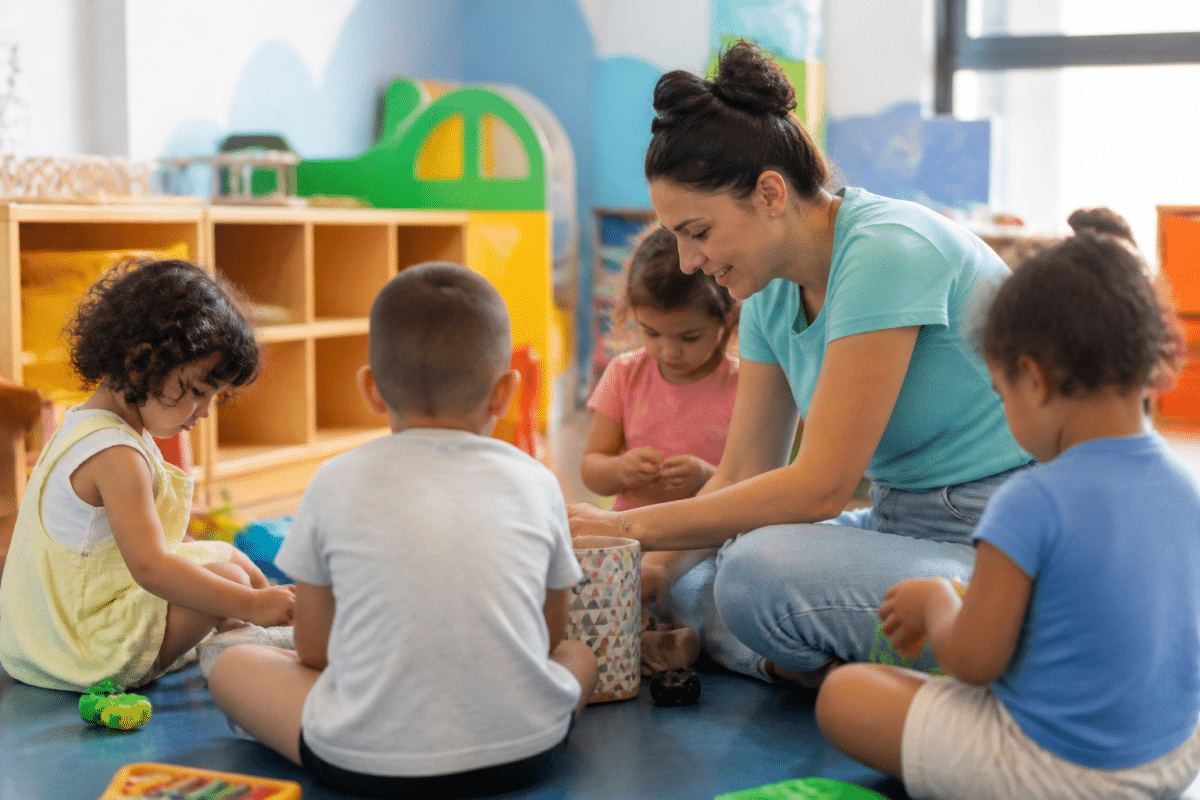 Educatrice jouant avec enfants dans une salle coloree