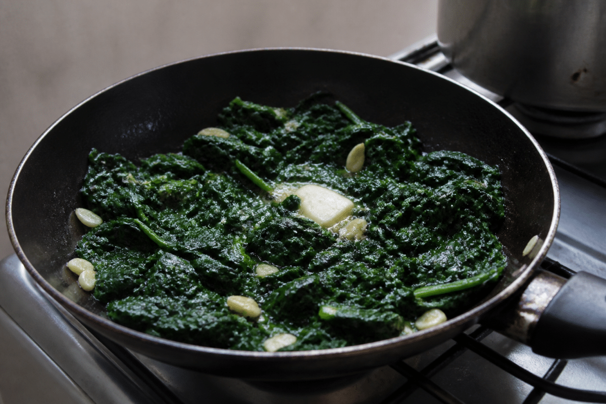 Epinards cuits verts dans poele avec ail et beurre