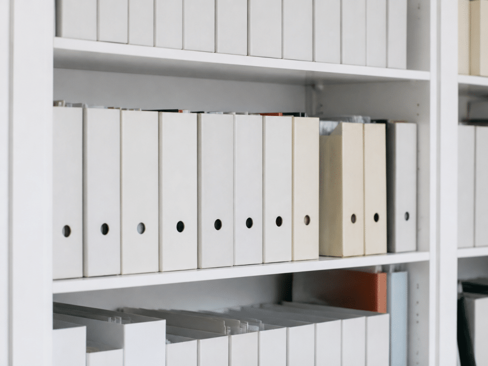 Etageres blanches remplies de boites rangees verticalement alignees