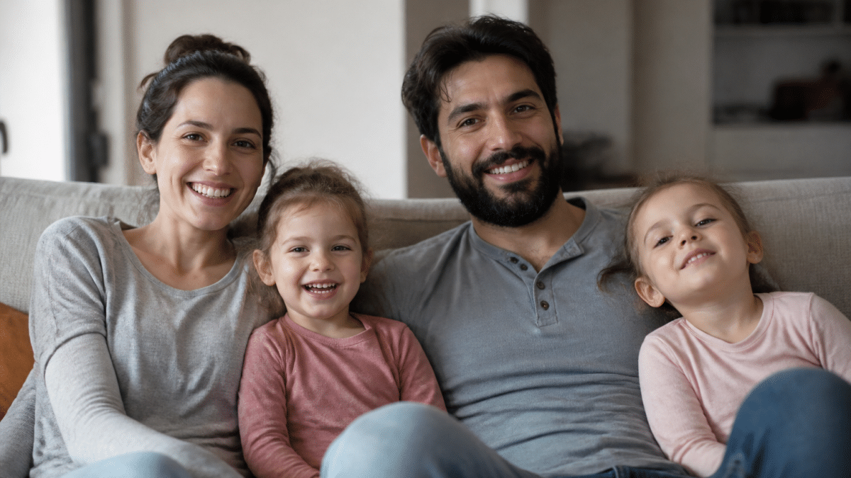Enfants et adultes assis ensemble sur un canapé souriant