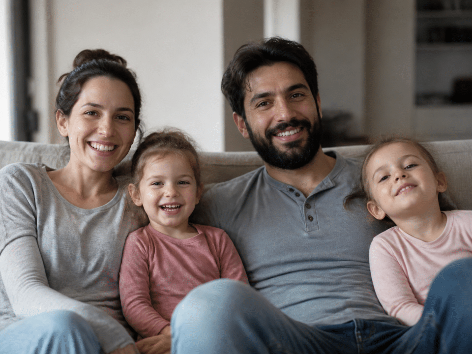 Enfants et adultes assis ensemble sur un canapé souriant