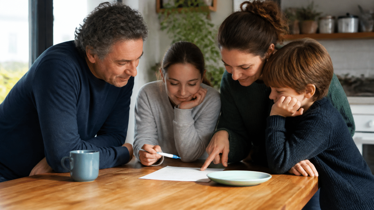 Famille autour table consultant planning taches menageres ensemble