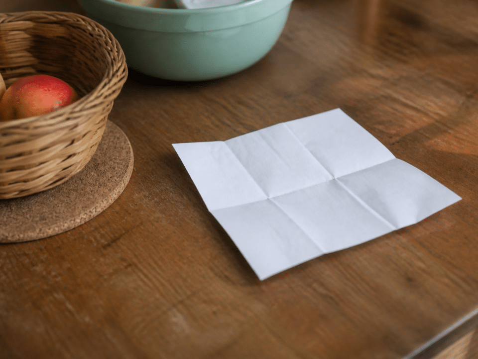 Liste de courses ecrite sur papier posee sur table de cuisine