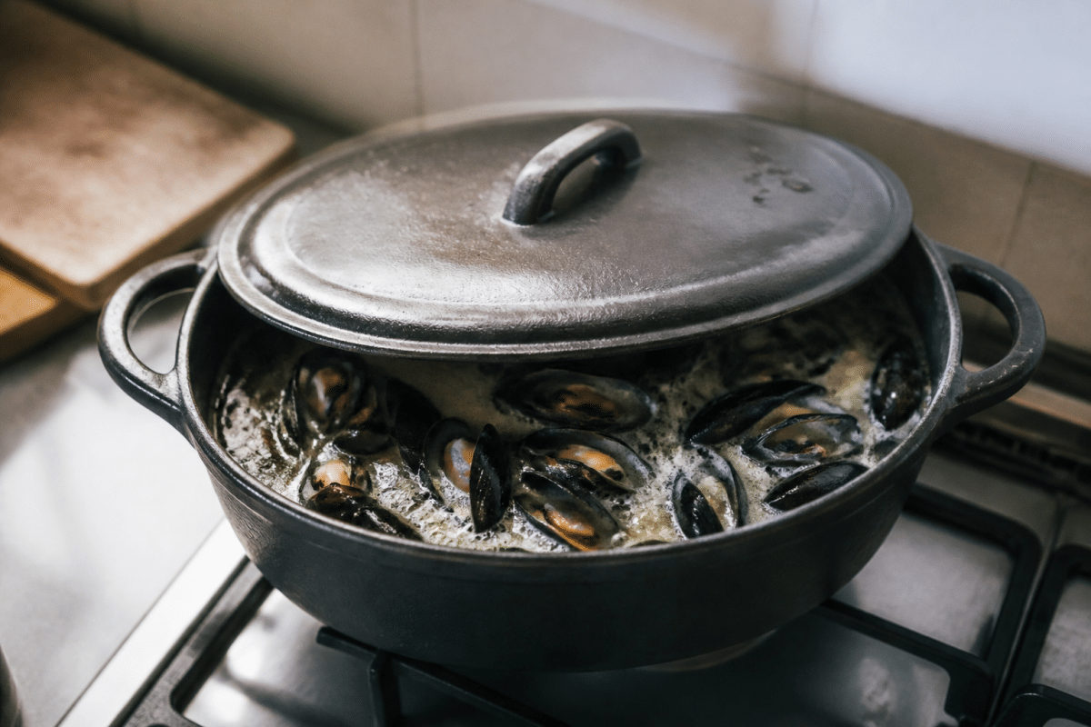 Casserole couverte avec moules et vin blanc frémissant