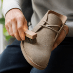Mains frottant brosse douce sur chaussure daim beige