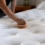 Personne frottant surface matelas blanc avec brosse circulaire