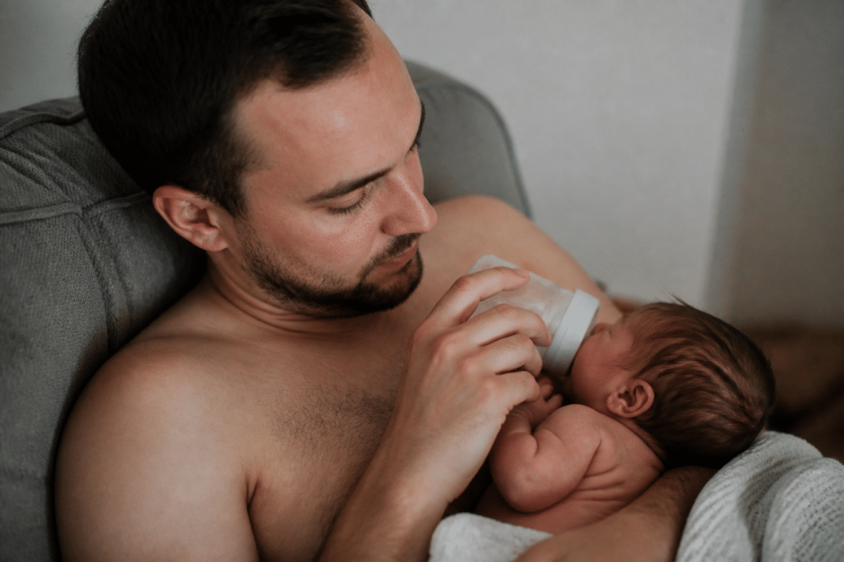 Papa donne biberon a bebe en peau a peau