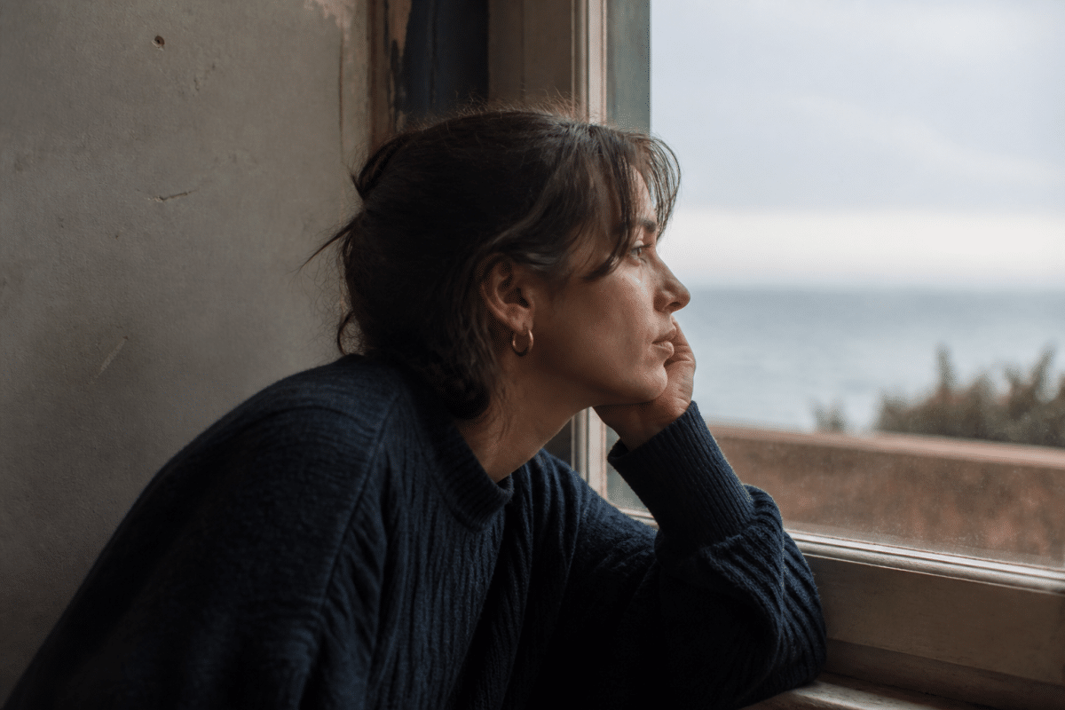 Personne contemplative regardant par la fenetre vers l'horizon