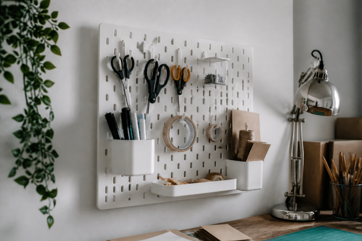 Panneau perforé mural avec crochets organisant ciseaux et fournitures bureau