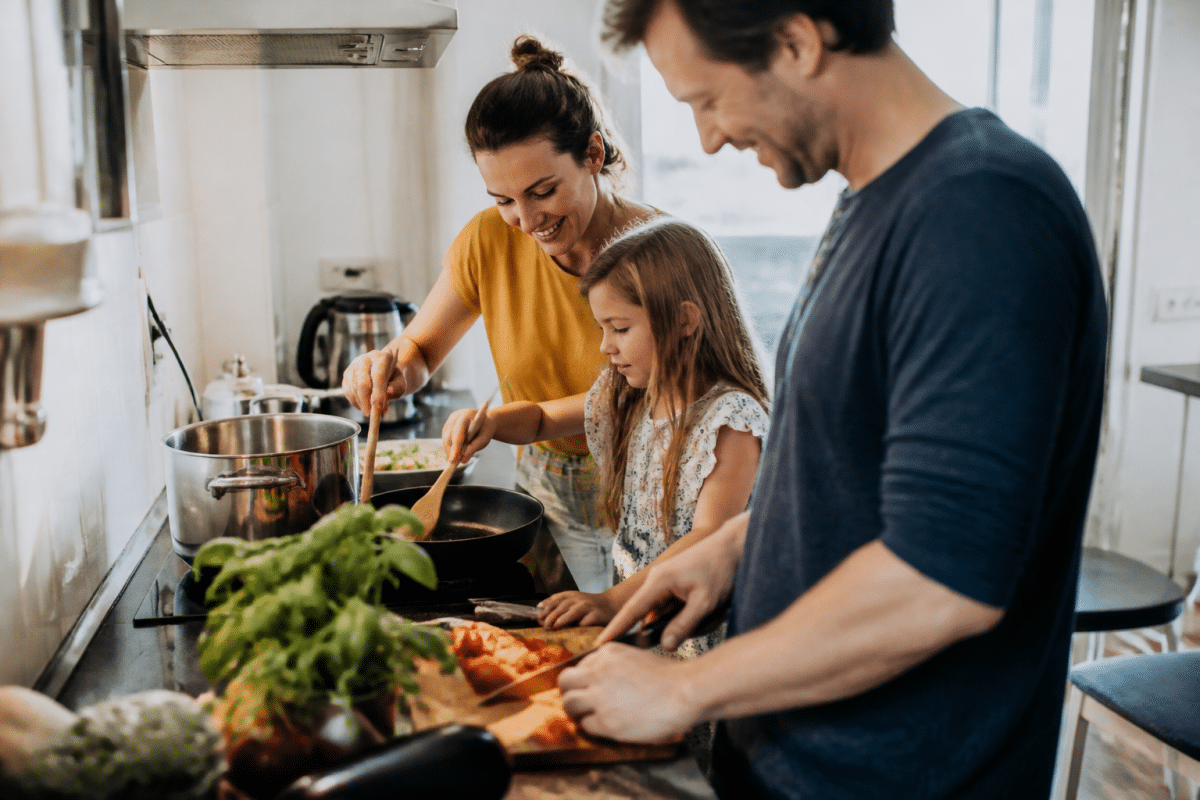 Famille cuisinant ensemble dans une cuisine lumineuse