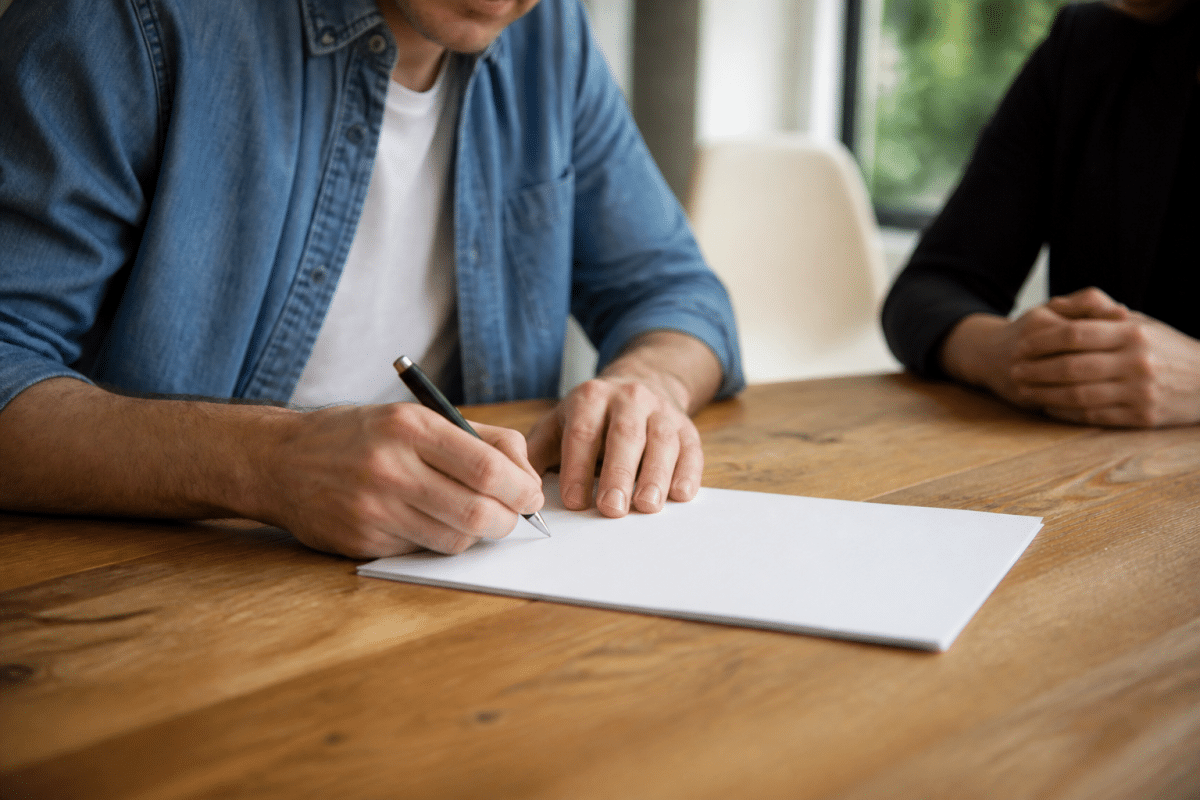 Contrat immobilier signé avec stylo sur table en bois