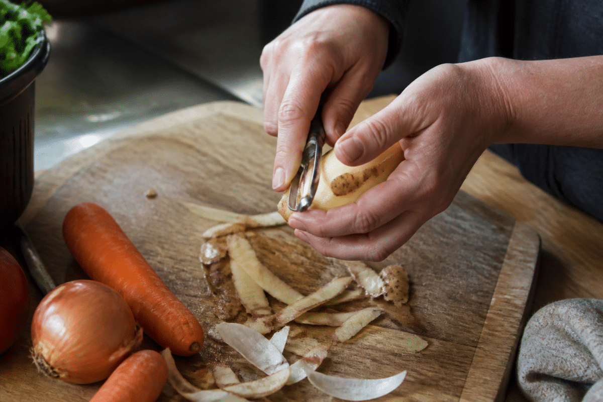 Couteau economе pelant peau legume cru sur planche bois